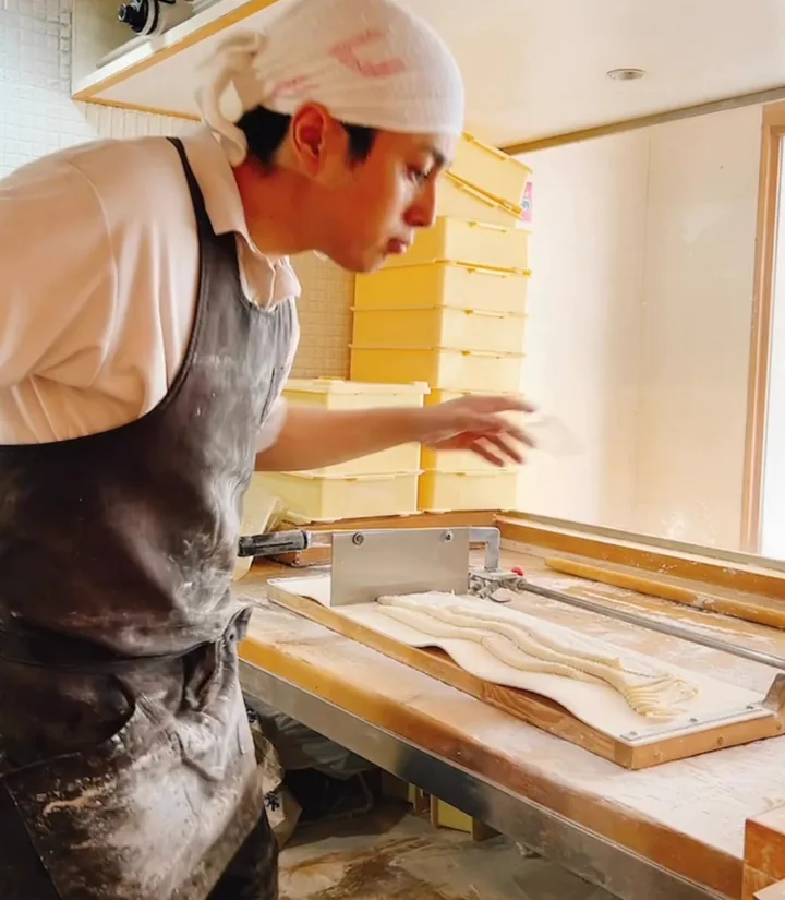 職人が包丁でうどんを切り出す手元